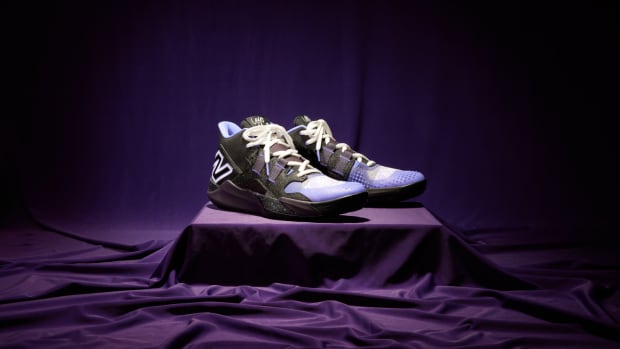 Side view of Coco Gauff's black and purple New Balance tennis shoes.